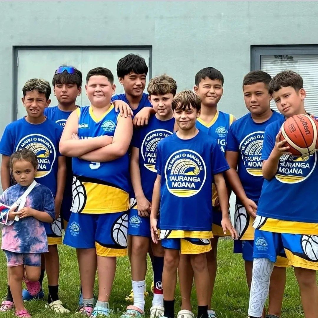 Young Te Maru o Mauao players in club shirts, arms around each other